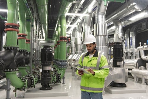 Technician inspecting industrial piping systems in Northern California